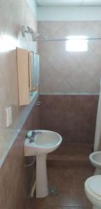 Un baño con un lavabo blanco y un inodoro. en Don cholo, en Buenos Aires