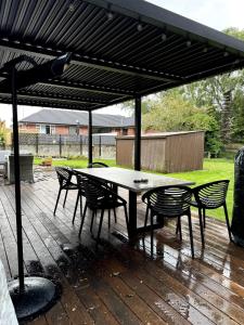 a patio with a table and chairs under an umbrella at Whare iti on Johns in Christchurch