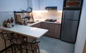 a kitchen with a refrigerator and a counter with stools at Confort en el Centro de Cuenca in Cuenca