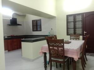 una cucina con tavolo, sedie e lavandino di Chandru Residency a Tiruvannāmalai