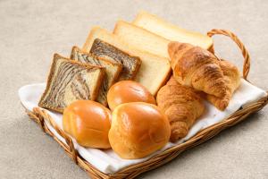 ein Korb mit Brot und Croissants auf einem Tisch in der Unterkunft Hotel Kansai in Osaka + 30 Fotos
