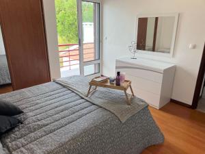 1 dormitorio con cama y mesa con espejo en Populo Beach Villa, en Livramento