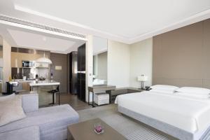 a bedroom with a bed and a living room at Hyatt House Shanghai Hongqiao CBD in Shanghai
