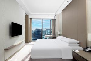 a bedroom with a large white bed and a large window at Hyatt House Shanghai Hongqiao CBD in Shanghai