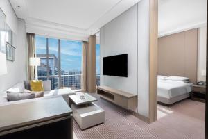 a hotel room with a bed and a large window at Hyatt House Shanghai Hongqiao CBD in Shanghai