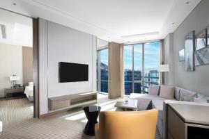 a living room with a couch and a tv at Hyatt House Shanghai Hongqiao CBD in Shanghai