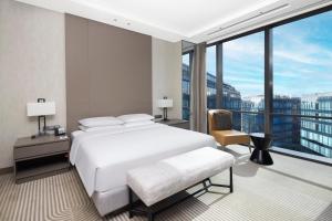a bedroom with a white bed and a large window at Hyatt House Shanghai Hongqiao CBD in Shanghai