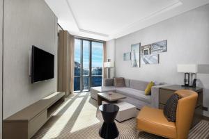 a living room with a couch and a tv at Hyatt House Shanghai Hongqiao CBD in Shanghai