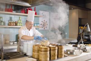 a chef preparing a cake in a kitchen at Hyatt House Shanghai Hongqiao CBD in Shanghai