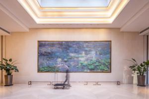 a large painting on a wall in a room with benches at Hyatt House Shanghai Hongqiao CBD in Shanghai