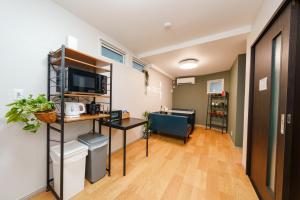 a small room with a desk and a microwave at Osaka Namba Yeon House in Osaka