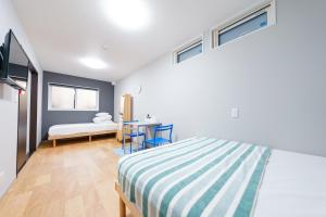 a bedroom with a bed and a desk in it at Osaka Namba Yeon House in Osaka
