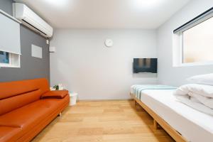 a bedroom with a bed and a couch at Osaka Namba Yeon House in Osaka