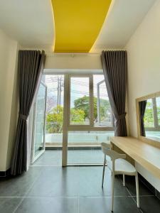a dining room with a table and a yellow ceiling at Baly Hotel Bà Rịa City in Bà Rịa