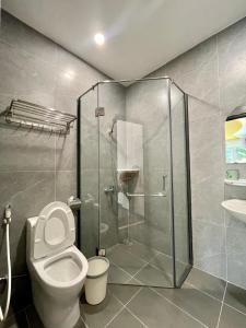 a bathroom with a toilet and a glass shower at Baly Hotel Bà Rịa City in Bà Rịa
