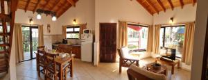 a kitchen and living room with a table and a refrigerator at Cabaña La Yuli in Santa Teresita