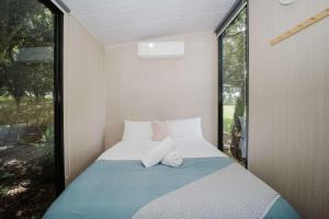 a small bedroom with a bed with towels on it at Spring Haven Retreat by Tiny Away in Eureka +21 photos