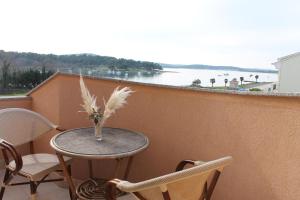 a table and chairs on a balcony with a view of the water at Apartments Lukas in Medulin