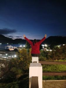 a person standing on a bench with their arms in the air at Patagon karim 2 in Puerto Cahacabuco