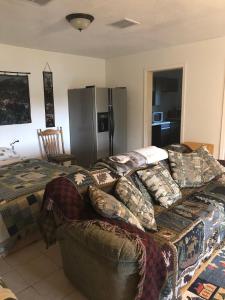 Una sala de estar con un sofá y un refrigerador. en Scout Lake Adventures - LAKE FRONT fishing avail, en Soldotna