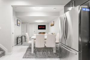 eine Küche und ein Esszimmer mit einem Tisch und einem Kühlschrank in der Unterkunft Entire 1 bed and Den Near YEG International Airport in Nisku