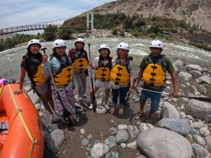 a group of people in life jackets standing next to a river at Hostal Aventura Total Perú_lunahuana in Lunahuaná