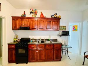 a kitchen with wooden cabinets and a sink and a stove at Yellow Beachfront Dream Home in Rosarito Beach