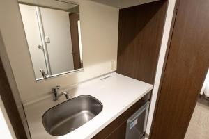 ein Badezimmer mit Waschbecken und Spiegel in der Unterkunft Hotel Alpha Inn Akita - Vacation STAY 67285v in Akita