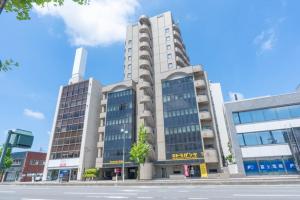 ein großes Gebäude mit Fenstern auf einer Stadtstraße in der Unterkunft Hotel Alpha Inn Akita - Vacation STAY 67286v in Akita