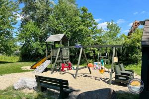 a playground with a swing set and a slide at Cozy Maple House Family Lake Como Retreat in Lake Geneva