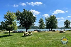 a group of picnic tables in a park near the water at Cozy Maple House Family Lake Como Retreat in Lake Geneva +52 photos