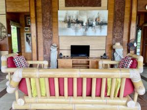 ein Wohnzimmer mit Couch und Flachbildfernseher in der Unterkunft Sang Tirta Resort in Penebel