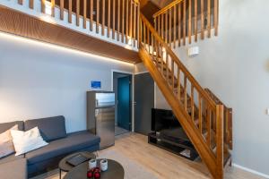 a living room with a couch and a staircase at Aurinkorinne 2 - Modern 2BD & Loft, free wifi & sauna in Syöte