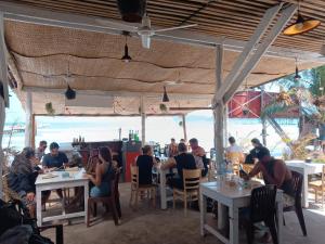 a group of people sitting at tables in a restaurant at Sunny Bungalow in Koh Rong Sanloem