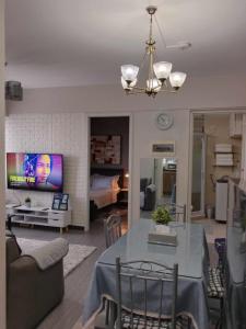 a living room with a dining table and a tv at Spacious 2 Bedroom condo unit for rent in Iloilo City
