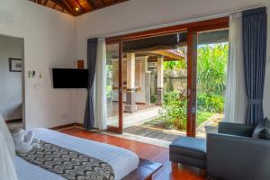 a bedroom with a bed and a sliding glass door at Bali Prime Villas Seminyak by Kanaya Hospitality in Seminyak