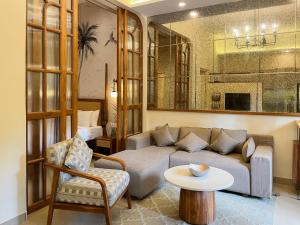 a living room with a couch and a table at Rainforest - Casa Azure 5 Min walk to the beach in Calangute