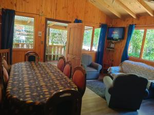 a dining room with a table and chairs in a room at Cabañas Coñaripe in Coñaripe