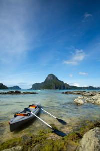 a boat sitting on the rocks in the water at Morgan Villas in El Nido +139 photos