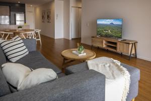ein Wohnzimmer mit zwei Sofas und einem Flachbildfernseher in der Unterkunft Rhythm on the Beach - Maroochydore Central in Maroochydore