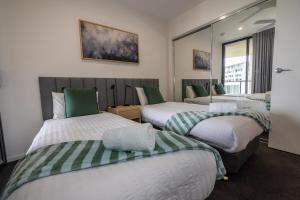 Zimmer mit 3 Betten in Grün und Weiß in der Unterkunft Rhythm on the Beach - Maroochydore Central in Maroochydore + 15 Fotos