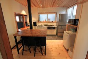 a kitchen with a wooden table and a counter top at Shinden 5 Bedroom Nozawa Townhouse in Nozawa Onsen +10 photos