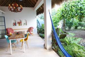 a patio with a table and chairs and a garden at Casa Clara 2 bedrooms and 2 kitchens with a Large Garden and a Record Player! in Lo de Marcos