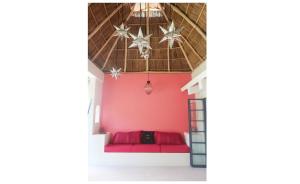 a room with a red couch and a ceiling with stars at Casa Clara 2 bedrooms and 2 kitchens with a Large Garden and a Record Player! in Lo de Marcos