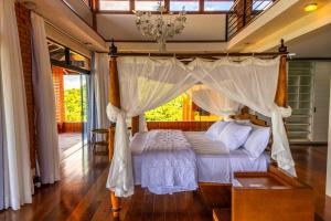 a bedroom with a bed with a canopy at Mansão VOAR in Florianópolis +131 photos
