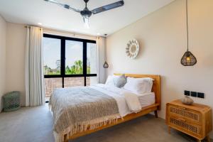 a bedroom with a bed and a large window at Villa Hati 2 in Canggu +23 photos