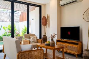 a living room with a television and a table at Villa Hati 2 in Canggu