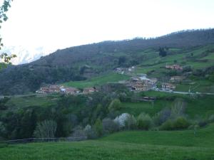 a village on a green hill with houses at Apartamento Fuente De Somave in Cahecho