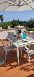 a white table and chairs on a patio at Patty's House in Finale Ligure