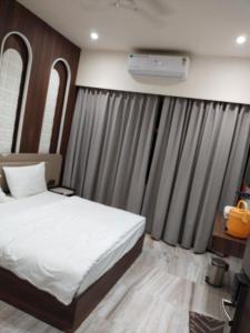 Un dormitorio con una cama blanca y una ventana. en Hotel Jai Palace, en Ajmer